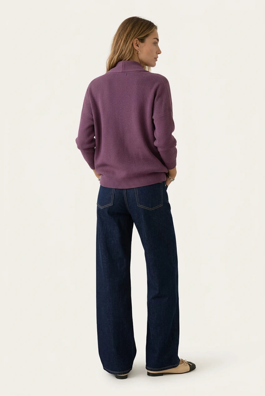 Back of the Menielle Antonine Sweater in mauve: knit sweater with a shawl collar and ribbed hem, with dark jeans