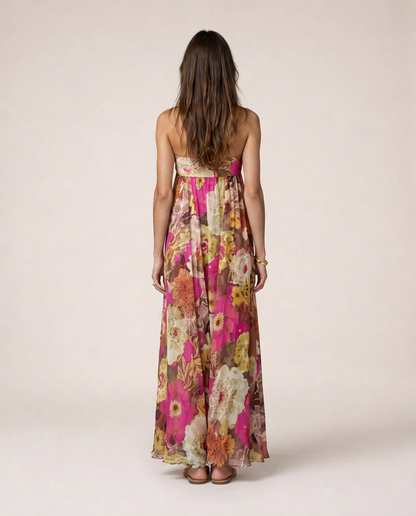 Bougainvillea Maxi Dress back view featuring a vibrant floral print in pink and coral tones, strapless neckline and flowing full-length silhouette