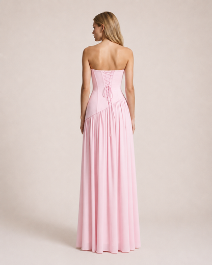 Luna Rosa Maxi Dress back view featuring an adjustable lace-up corset bodice and flowing floor-length skirt in soft blush pink