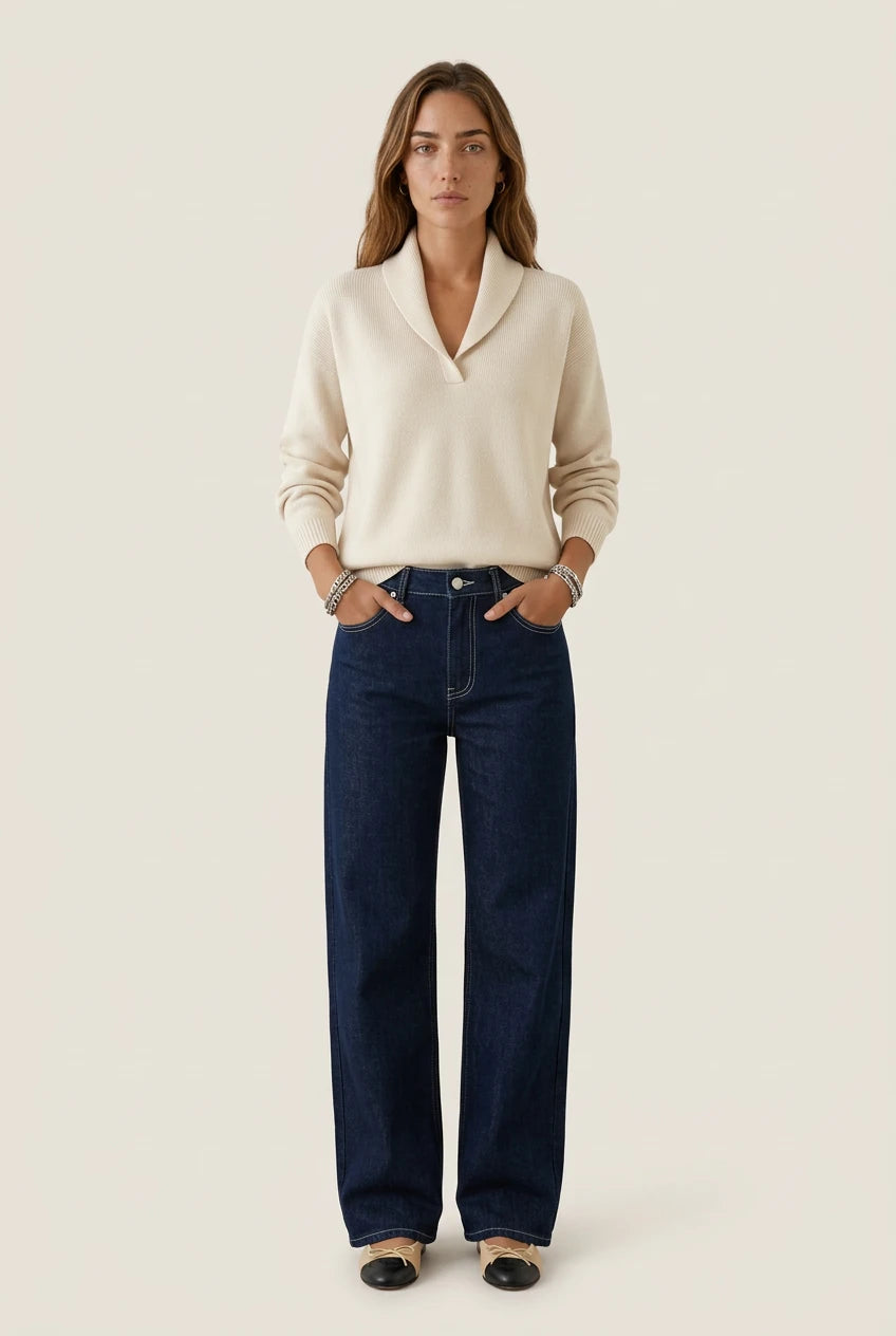 Mujer con el Antonine Jersey beige de Menielle, cuello chal en V y manos en los bolsillos de unos vaqueros oscuros anchos