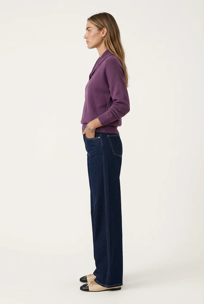 Side view of the Menielle Antonine Sweater in mauve: knit sweater with a V-shaped shawl collar and ribbed cuffs, with dark jeans