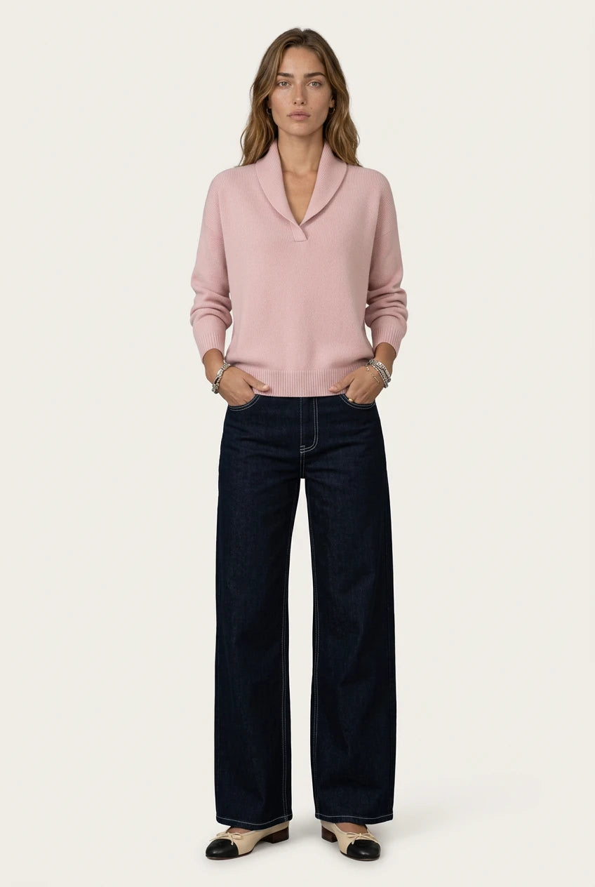 Mujer con el Antonine Jersey rosa de Menielle, cuello chal en V y manos en los bolsillos de unos vaqueros oscuros anchos