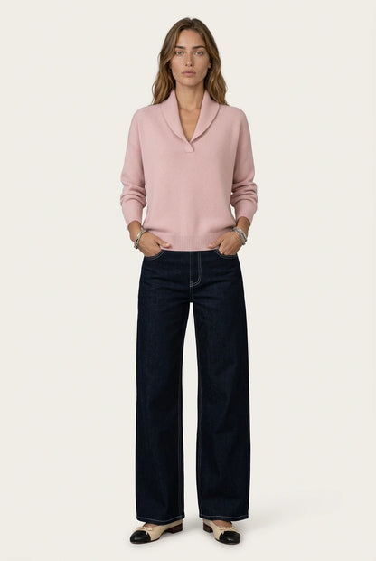 Mujer con el Antonine Jersey rosa de Menielle, cuello chal en V y manos en los bolsillos de unos vaqueros oscuros anchos